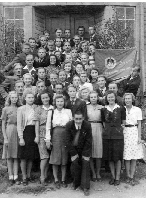 Joukk0 1940-luvun asuissa olevia nuoria. Ja yhdistyksen lippu.